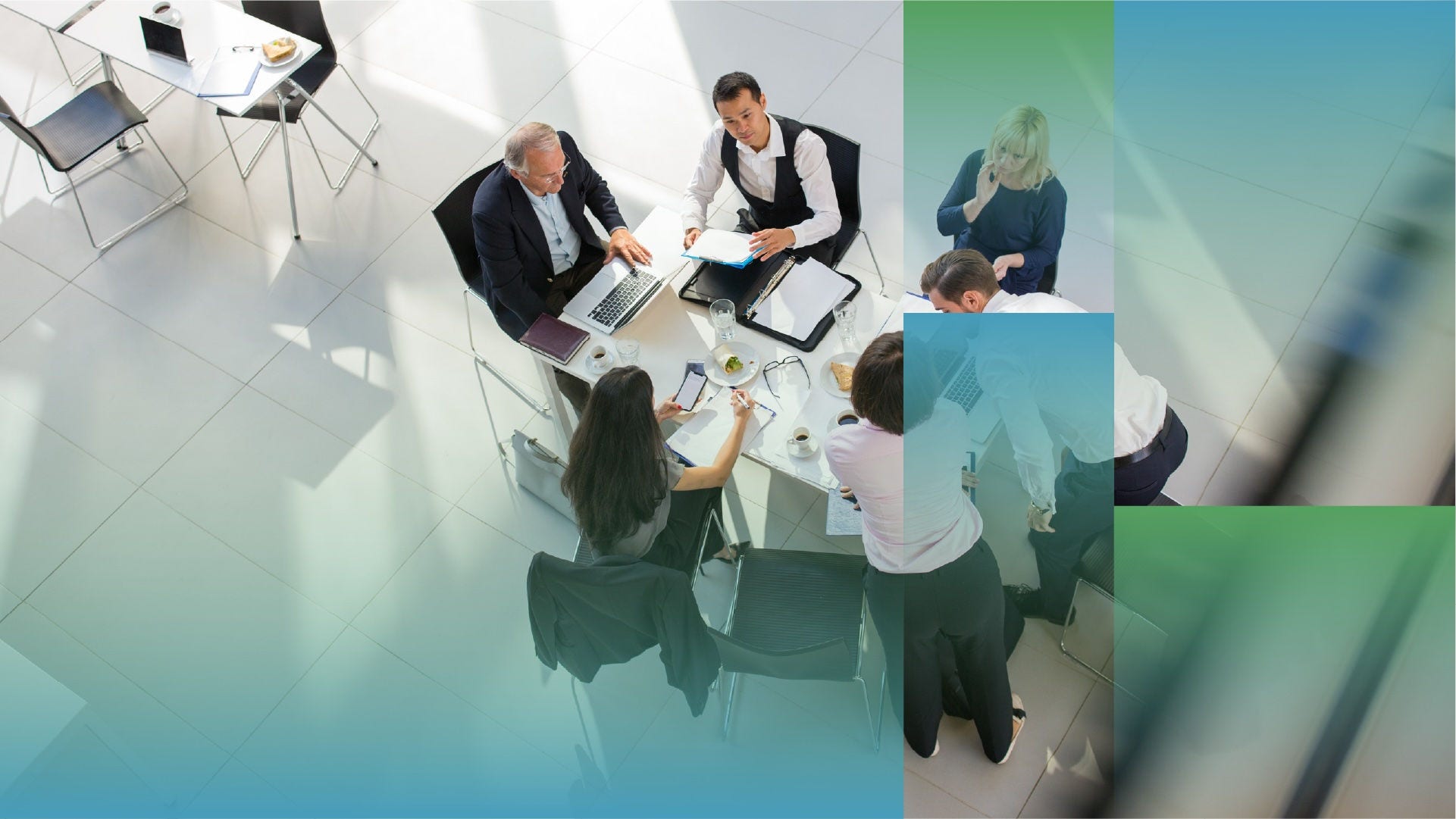 Overhead view of several people seated around a small round table in a bright office space, working with laptops, documents, notebooks, and coffee cups, with abstract blue and green graphic overlays partially framing the scene.