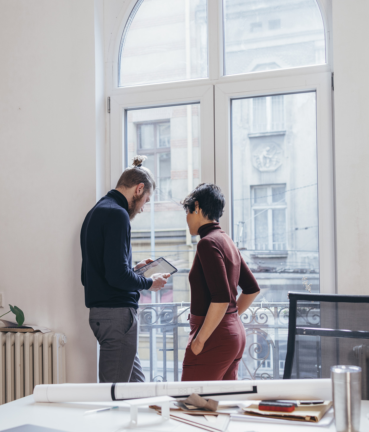 Collègues debout près d’une fenêtre